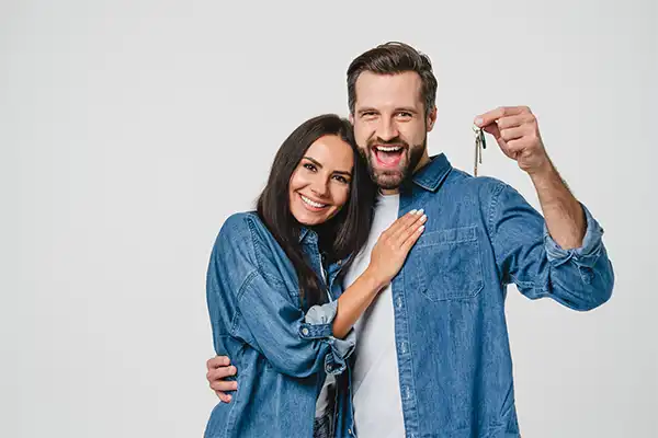 happy couple holding keys to new house