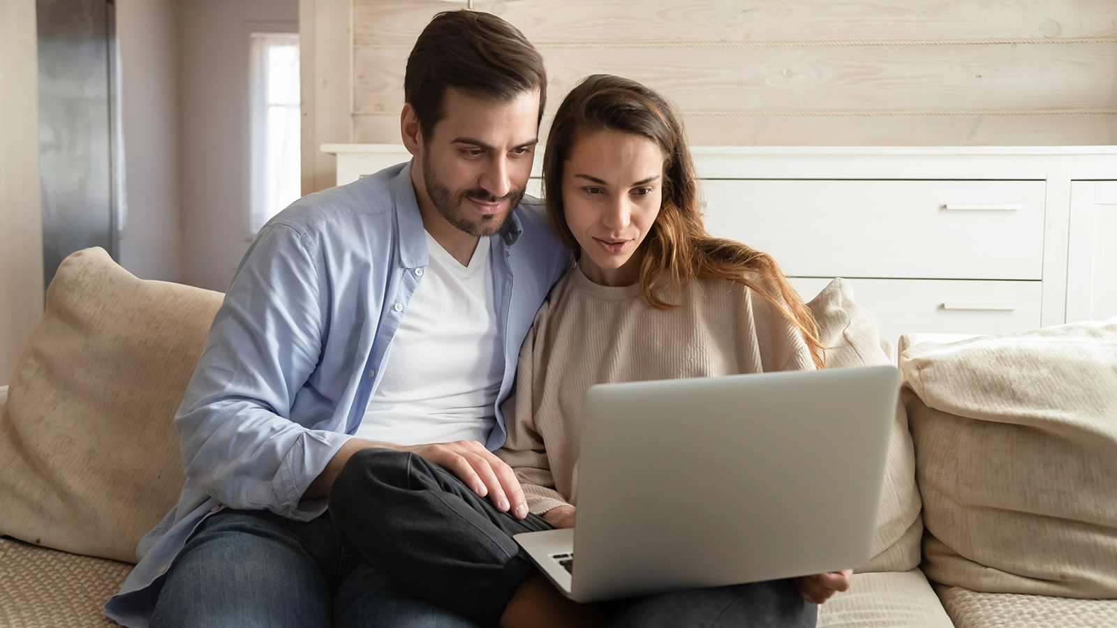 married couple searching online laptop