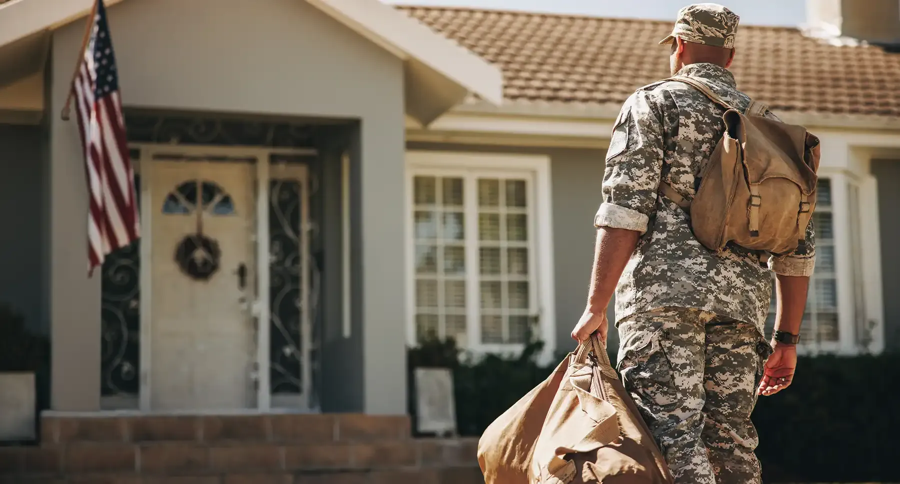 Active-duty service member standing in front of a South Carolina home after a VA IRRRL streamline refinance with PBT Bancorp