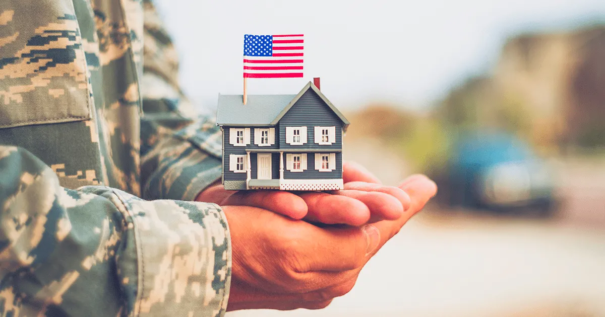 Hand holding a small model home, representing a Maryland veteran refinancing with a VA IRRRL streamline refinance from PBT Bancorp