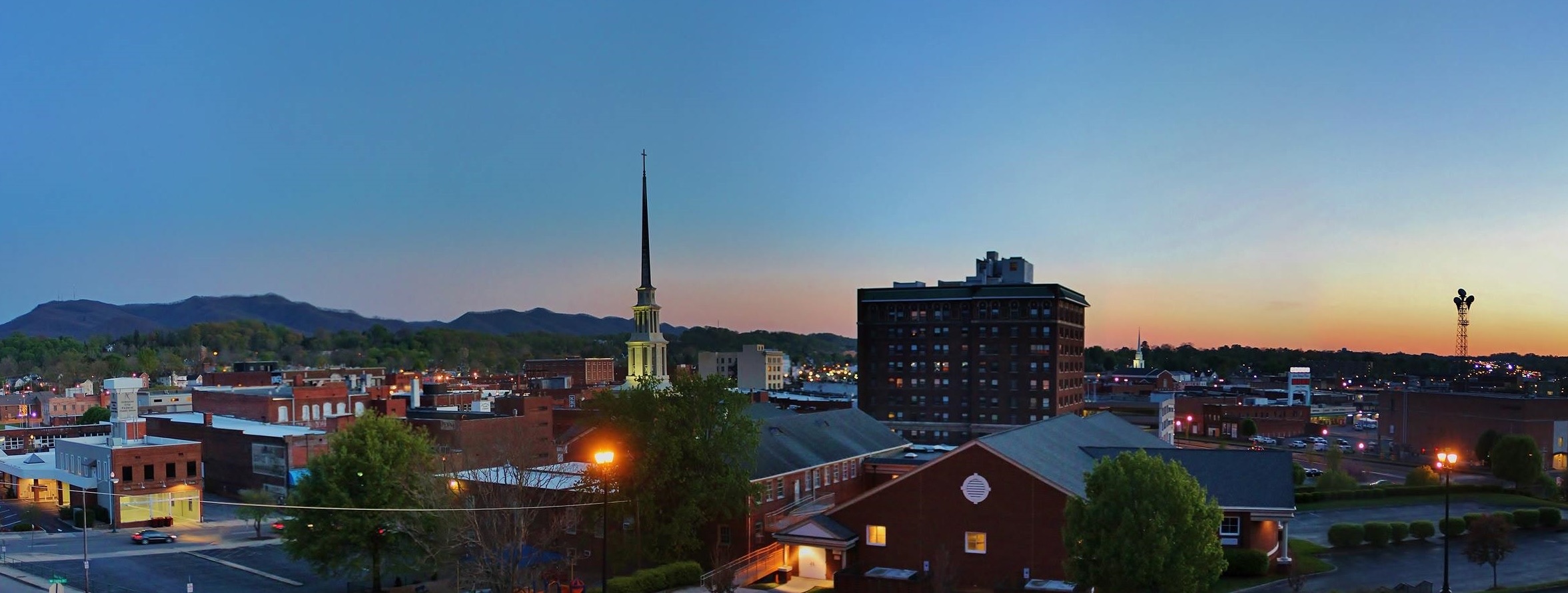 Downtown Johnson City, Tennessee at sunset with Buffalo Mountain behind it, where PBT Bancorp helps Veterans buy and refinance homes with VA loans