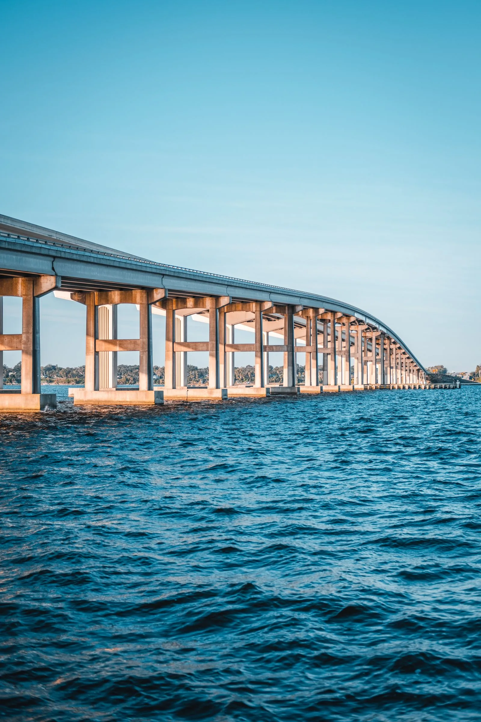 The Pensacola Bay Bridge over blue water under a clear sky, where PBT Bancorp helps Veterans buy with VA loans