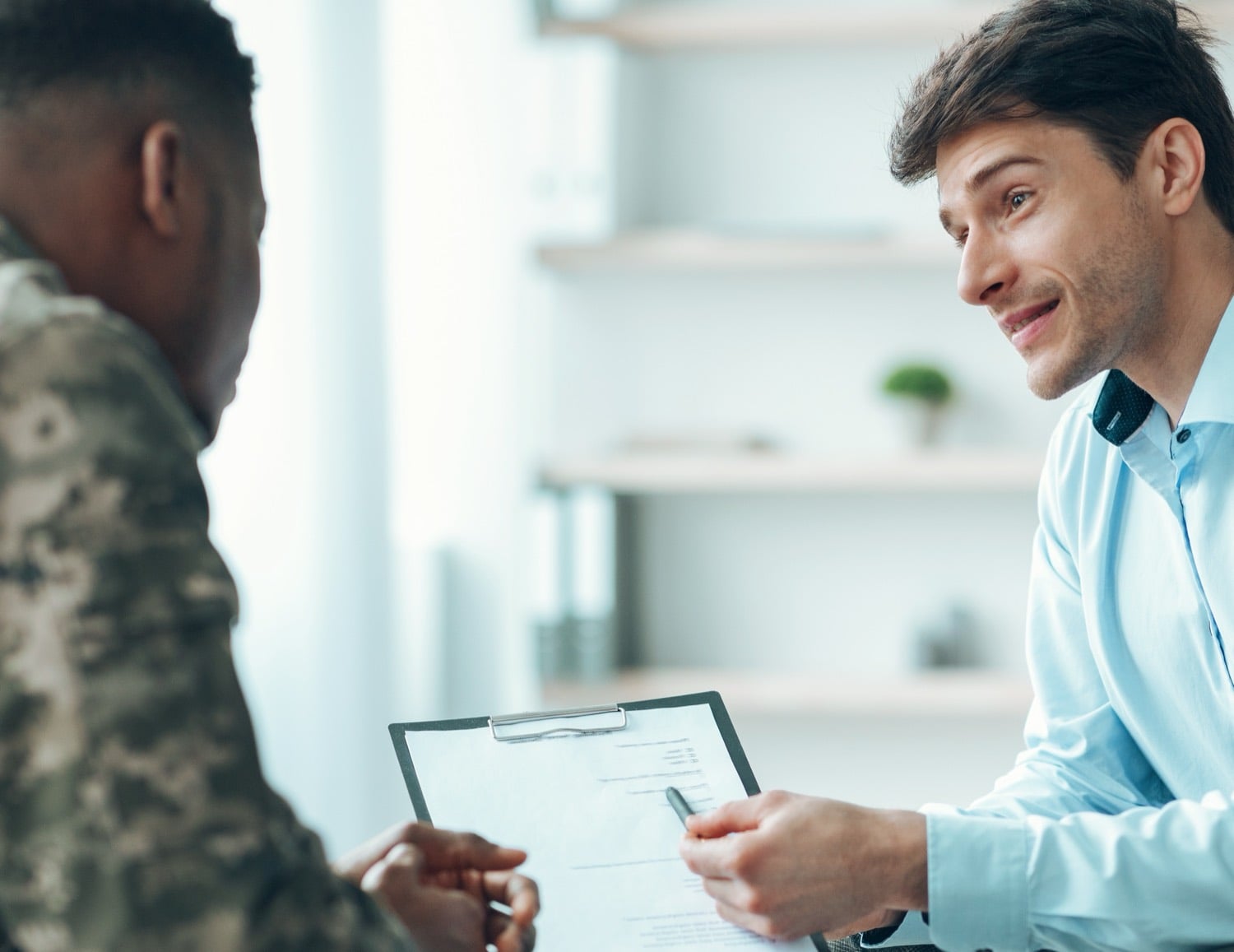 Service member in uniform and a PBT loan officer reviewing a written VA rate quote together