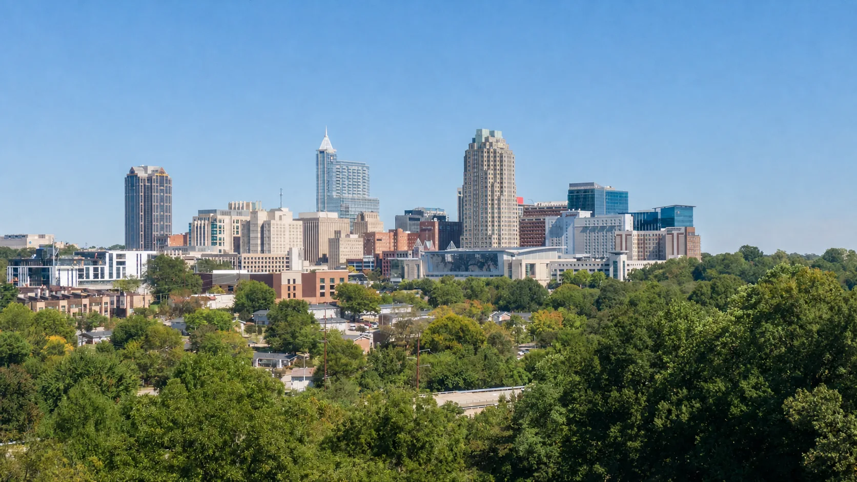 Downtown Raleigh skyline with modern office towers under a blue sky