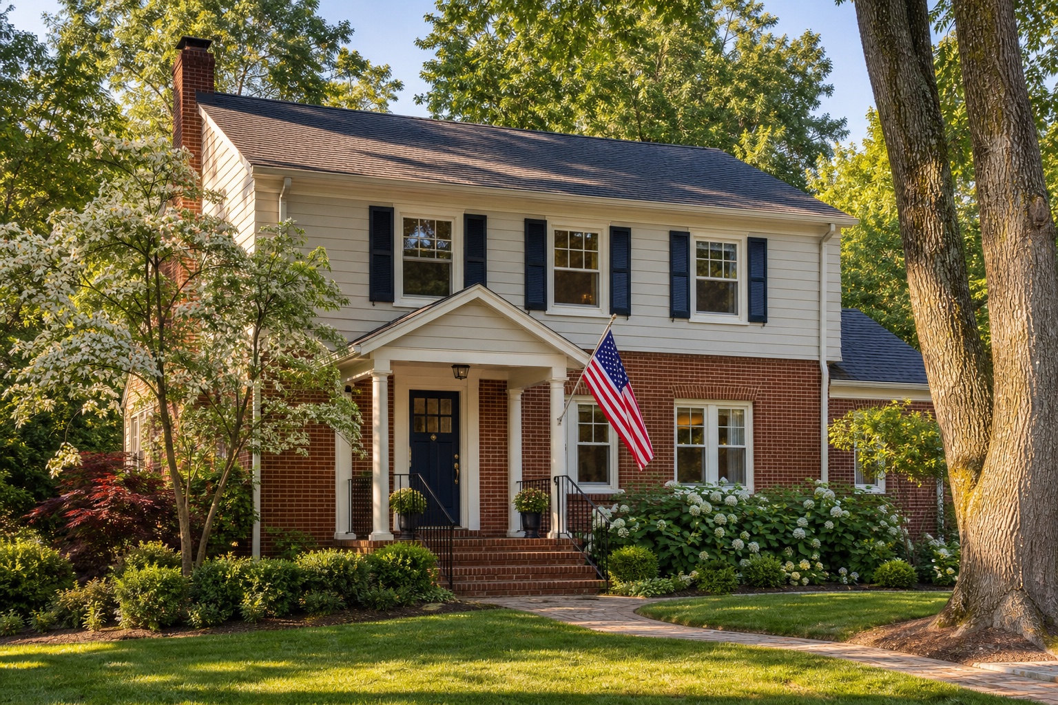 Maryland home for a VA IRRRL land-record and cost review Maryland brick and clapboard home with a navy door, hydrangeas, and an American flag